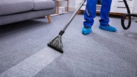 a man cleaning a carpet in a living room